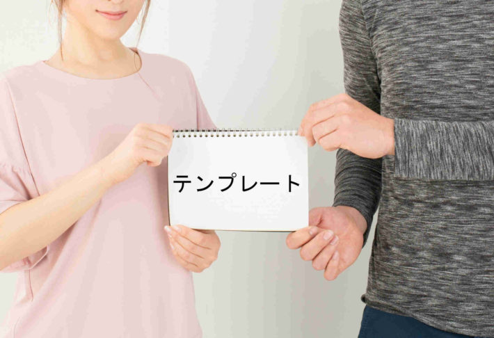 テンプレートと書かれた画用紙を持ち合うカップル