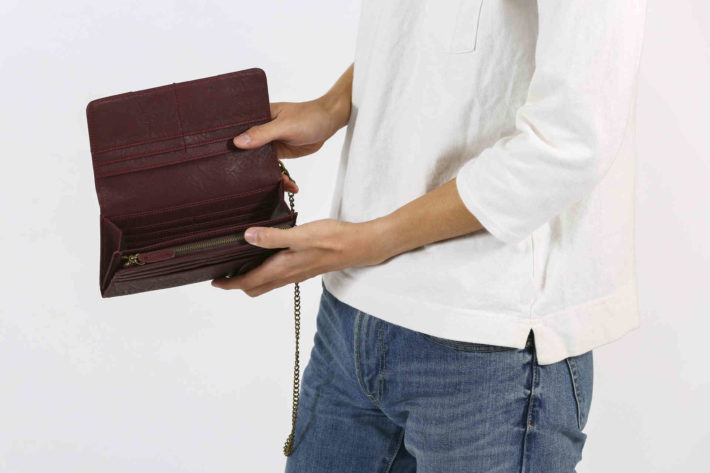 すっからかんの財布を見せている男性