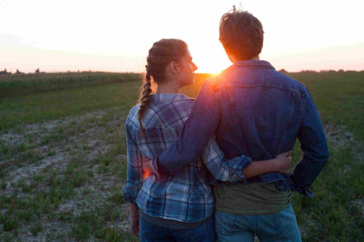 夕日を見つめる男女のカップル