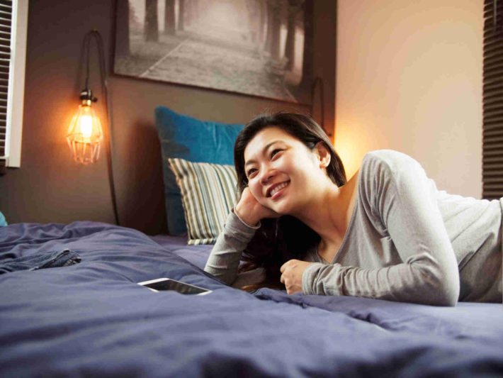 ベッドに横になりくつろいでいる女性