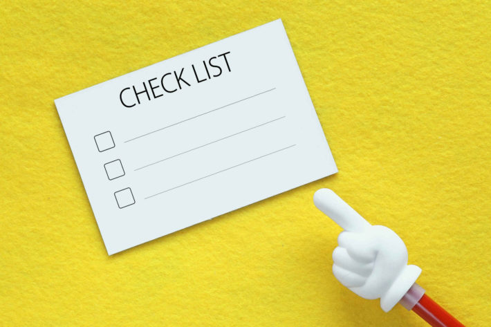 黄色の台紙の上に置かれたチェックリストの画像