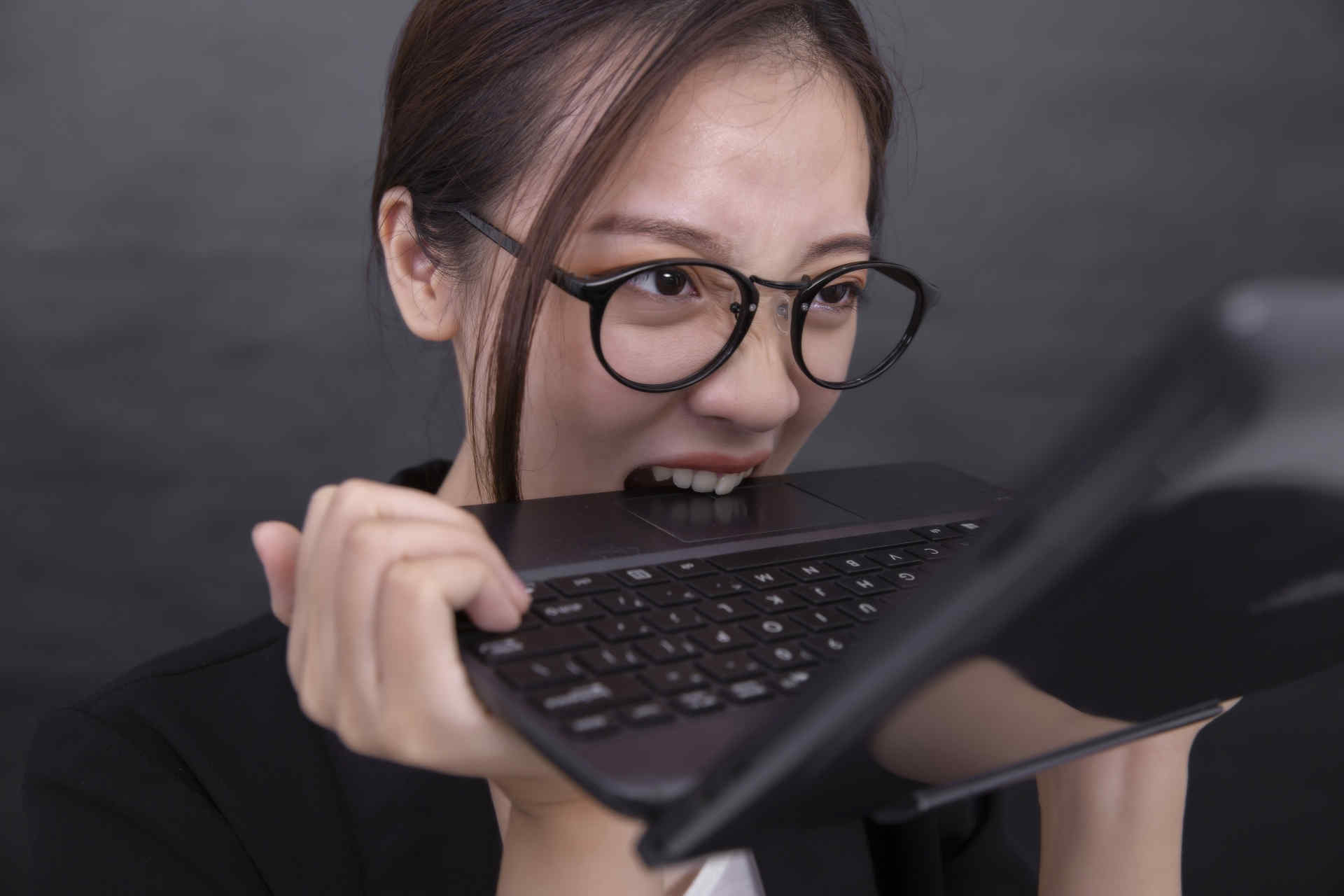 キーボードを噛んでいる女性