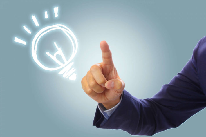 人差し指を立てているスーツ姿の男性