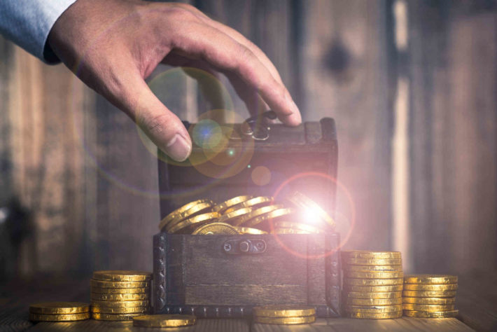 お金が入っている宝箱を開ける男性の手