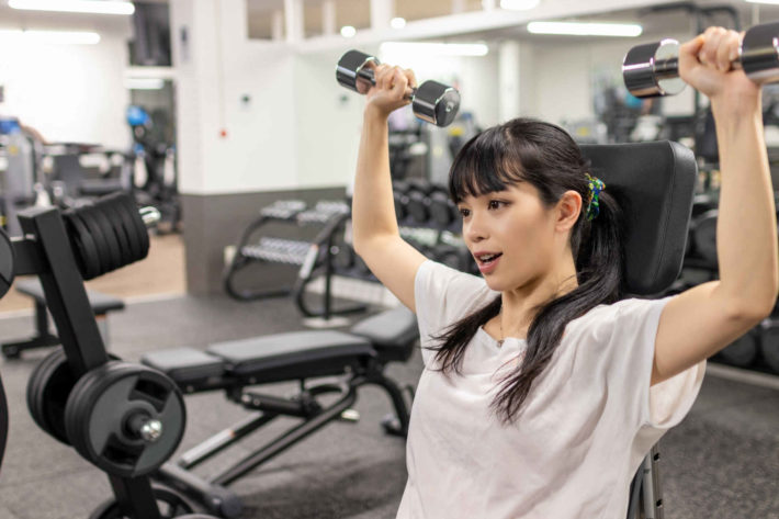 フィットネスジムでトレーニングしている美人女性