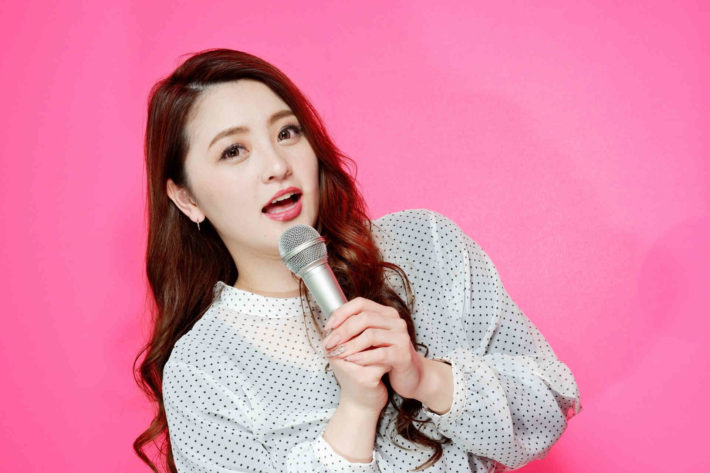 マイクを持って歌う女性