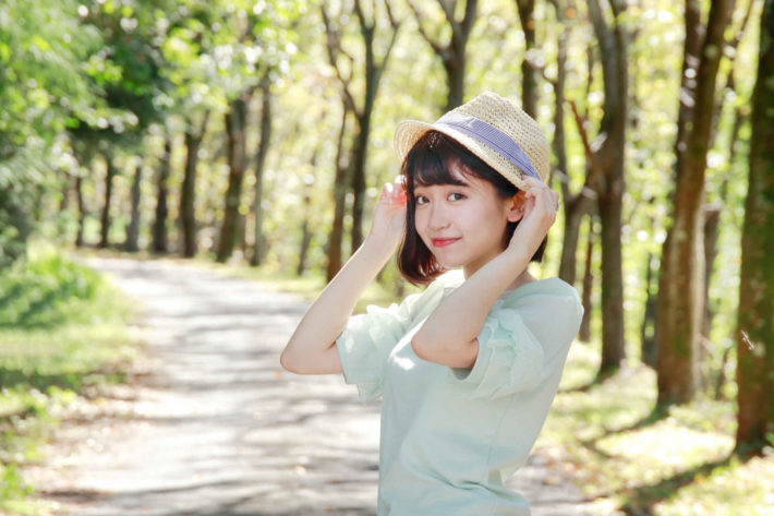 並木道で振り返っている可愛い女性