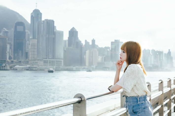 ハーバーで海を見て黄昏れている女性の横顔