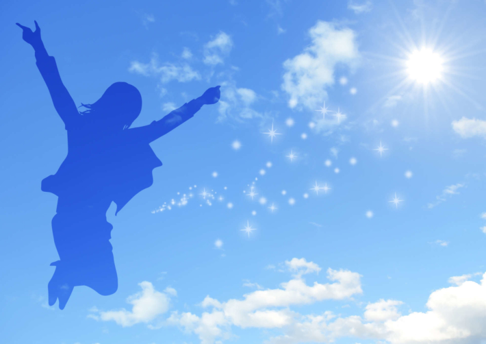 空に映った、ジャンプしている女性のシルエット