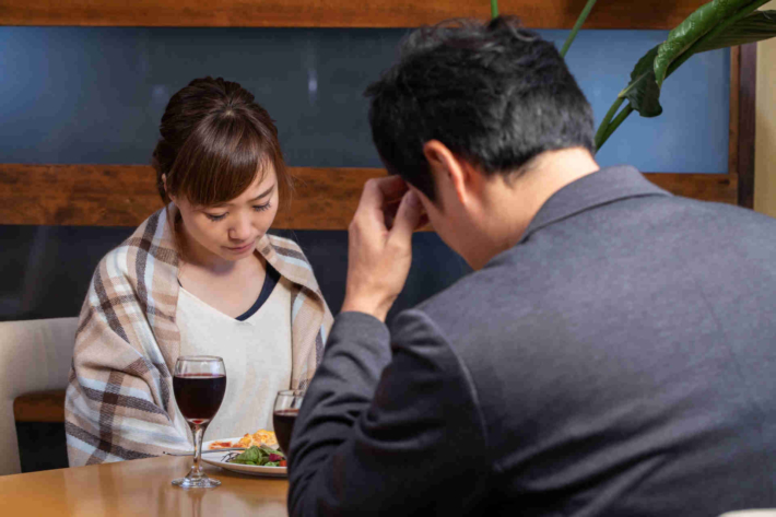 向かい合って俯いている男女