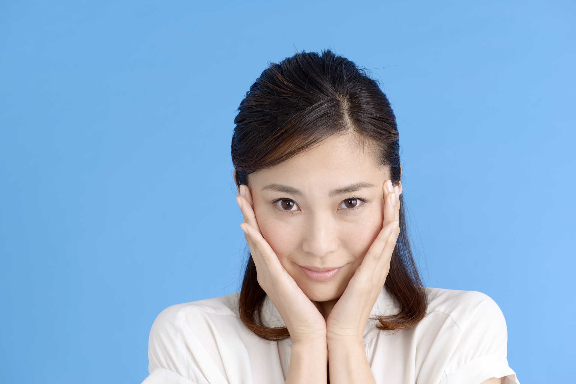 頬に手を当てて恥ずかしそうにしている女性