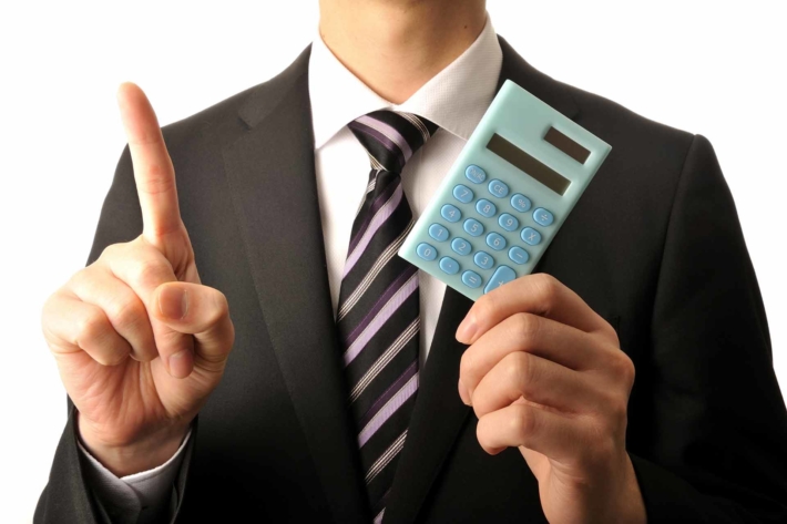 電卓を持つスーツ姿の男性