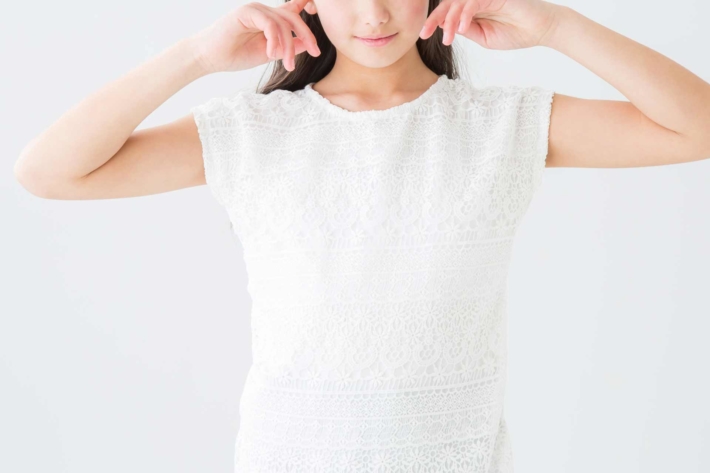 耳をふさぐ女性