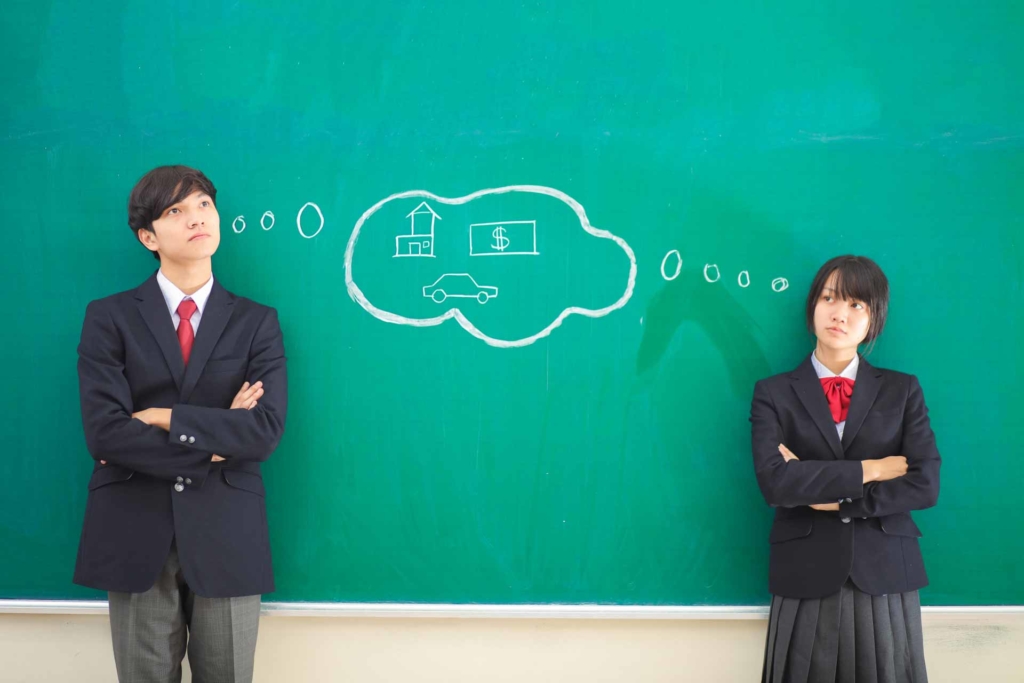 黒板の前に立って考えている男子と女子