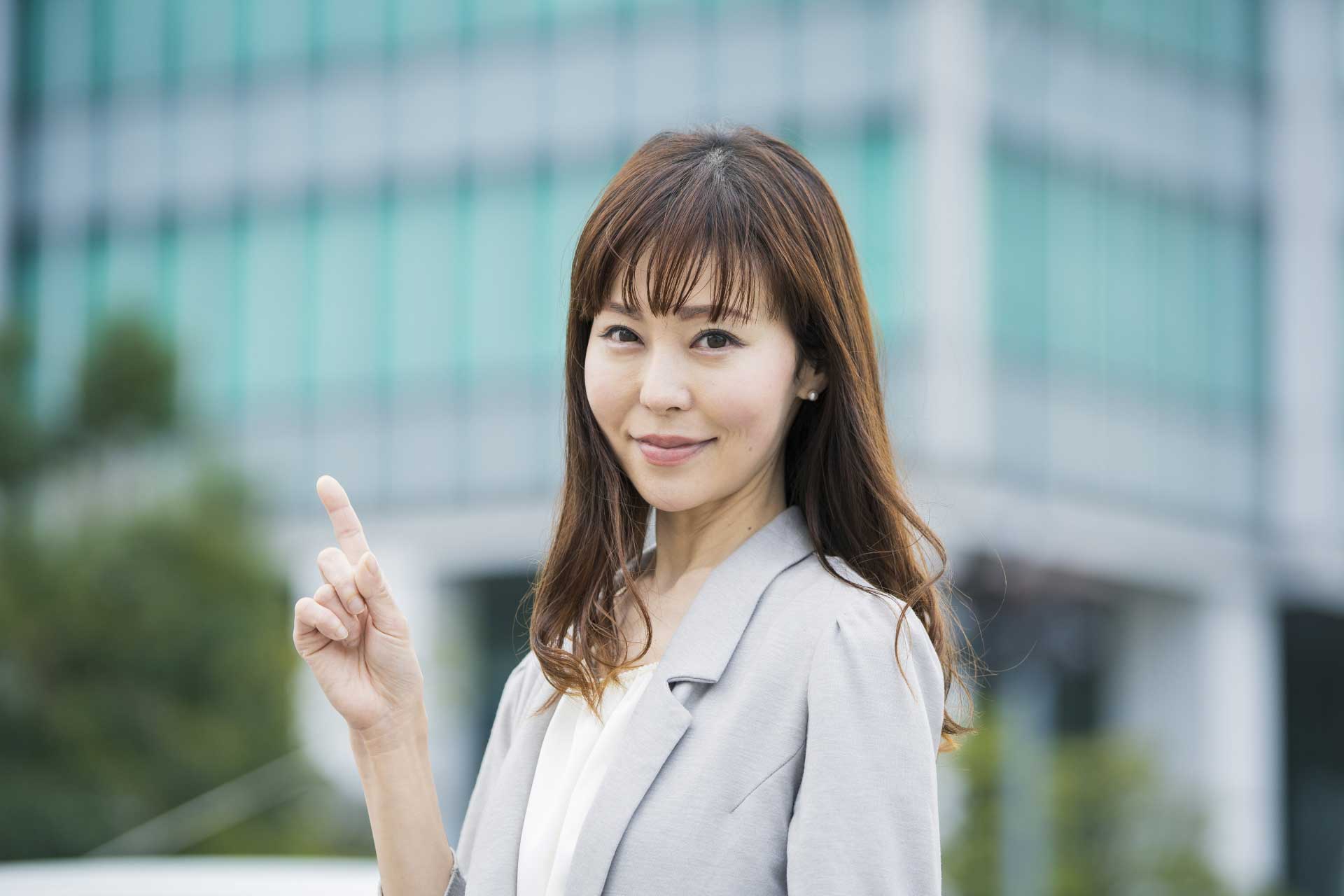 人差し指を立てているスーツ姿の女性