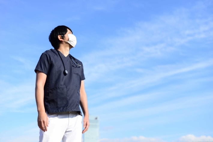 青空を見上げている男性介護スタッフ