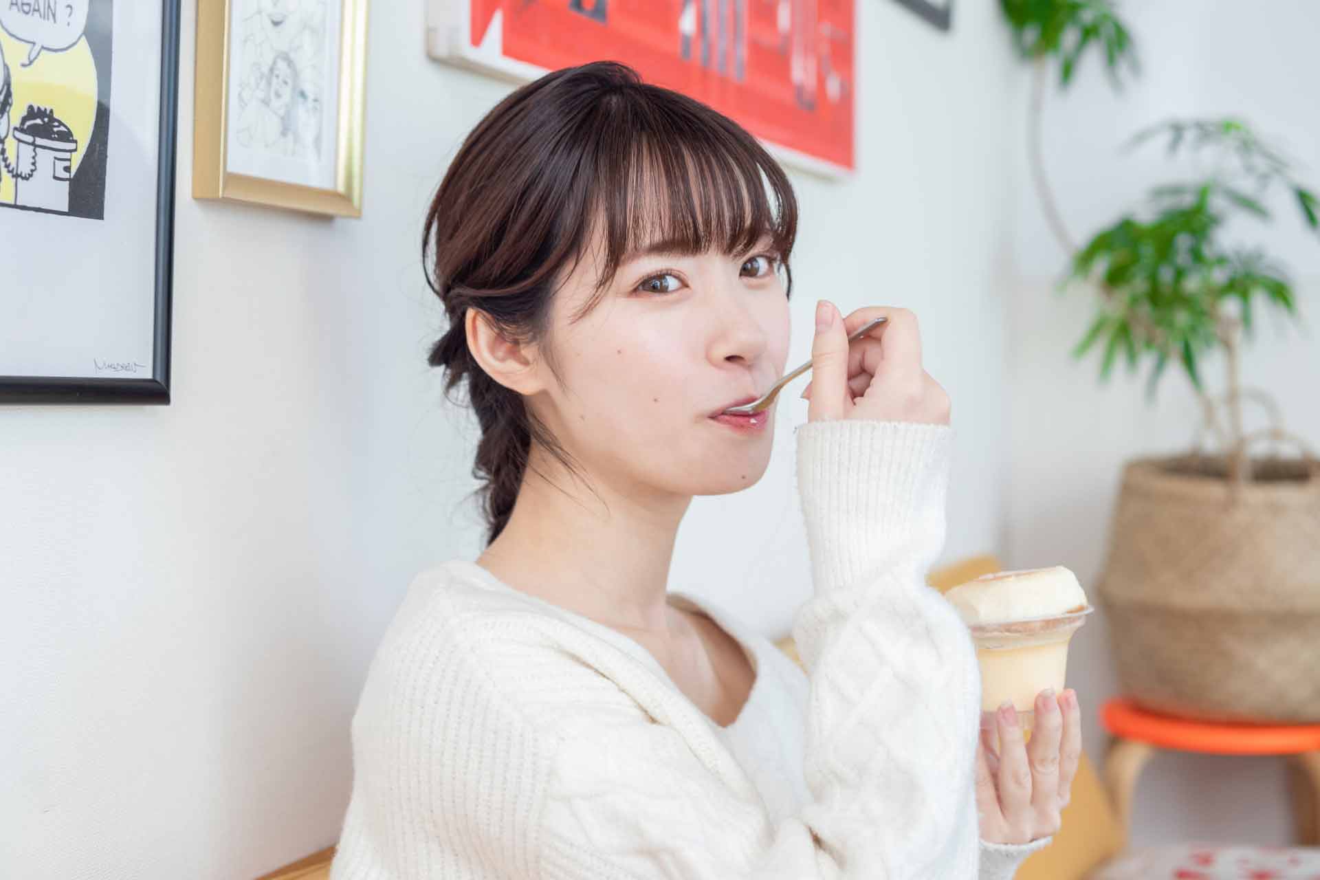 スプーンでスイーツを食べている女性