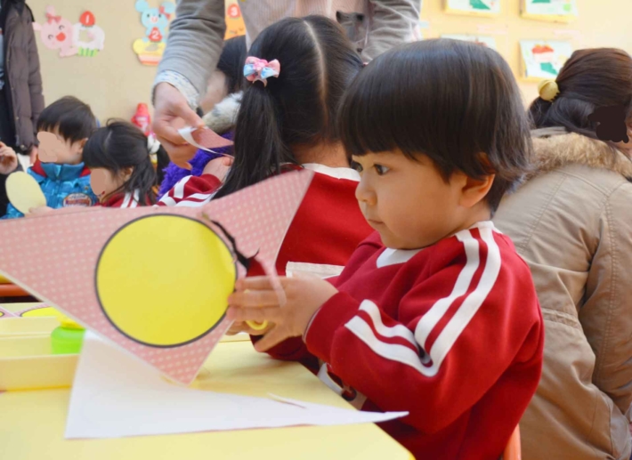 図工の時間で画用紙を鋏で切っている女の子