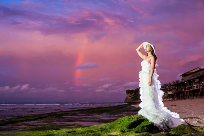 夕焼けを背景に空を見つめるウエディングドレス姿の女性