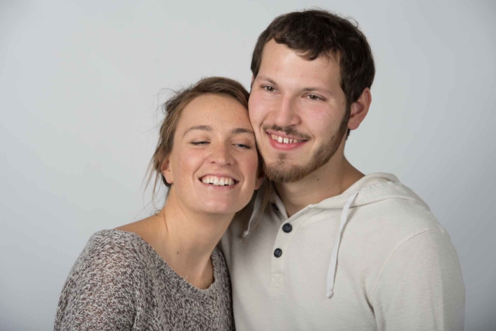 頬を寄せ合い笑っている外国人のカップル