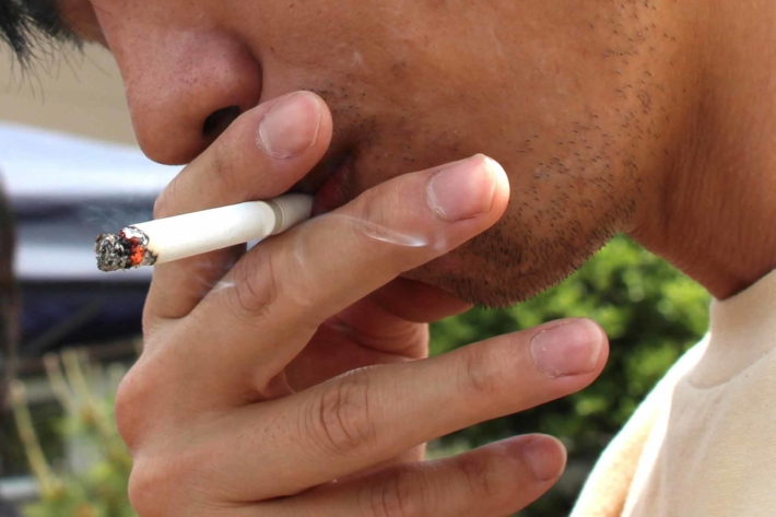 野外でタバコを吸っている男性の口元