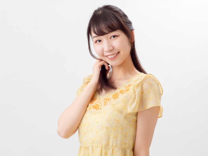 顎に手をあてて微笑んでいる女性