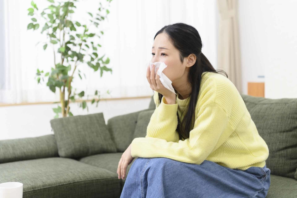 ソファーで寂しそうにTVを見ている女性