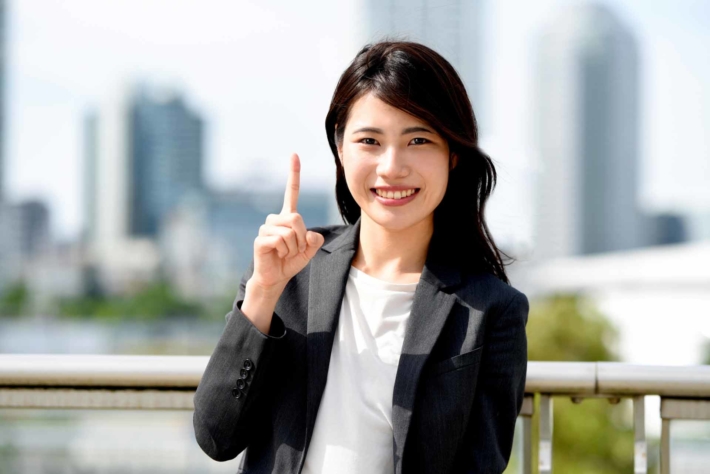 人差し指を立てている笑顔の女性