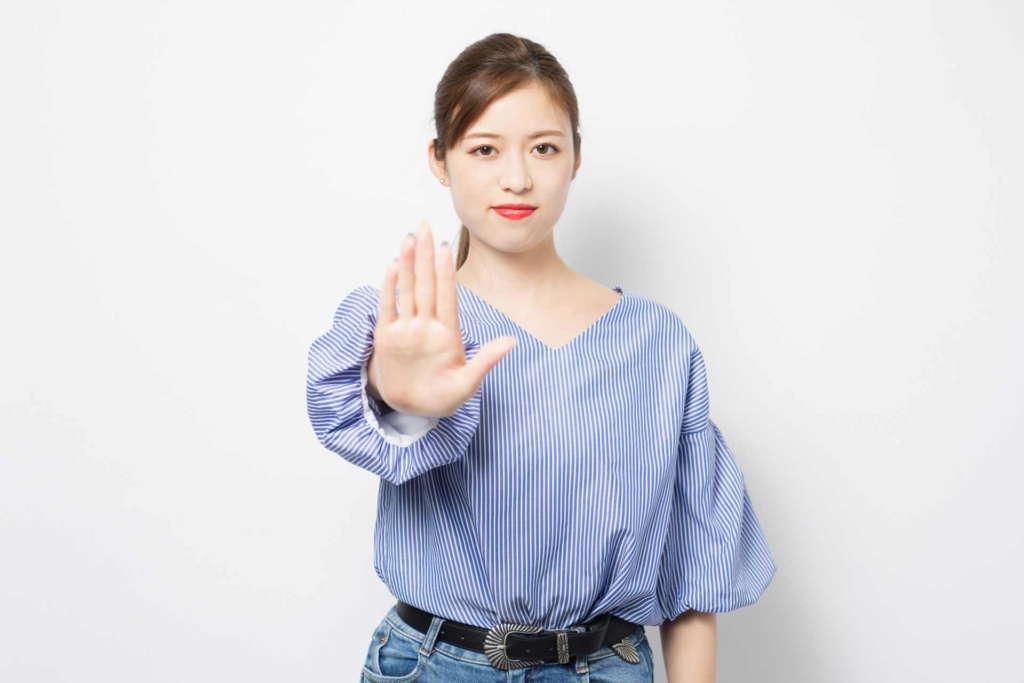 掌を前に出し静止しようとしている女性