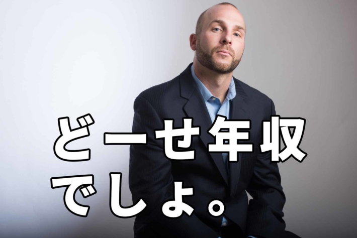 「どーせ年収でしょ」と書かれたテキストと見下すスーツ姿の男性