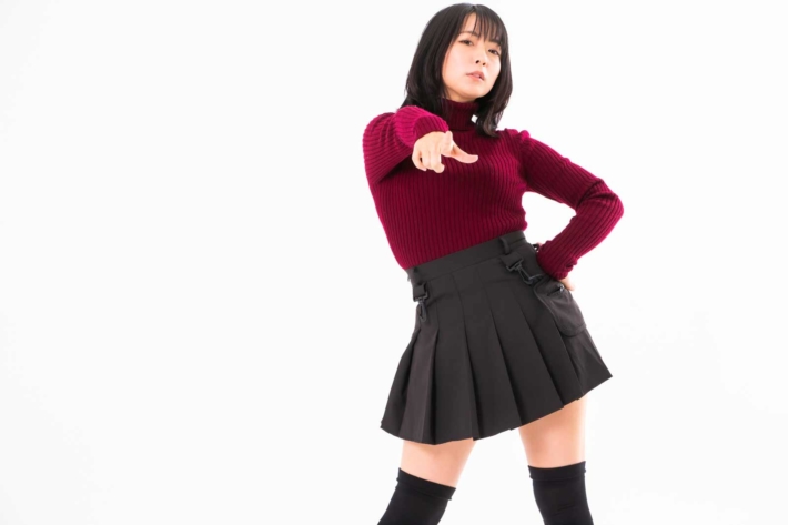 腰に手を当てて高圧的に指を指す大学生