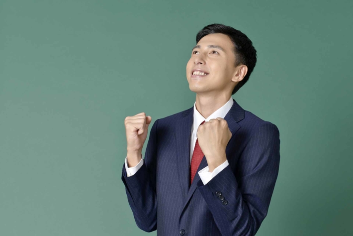 ガッツポーズして気合を入れているスーツ姿の男性