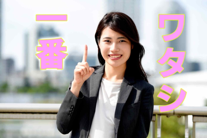 「ワタシ一番」と書かれたテキストに人差し指を立てて微笑む女性
