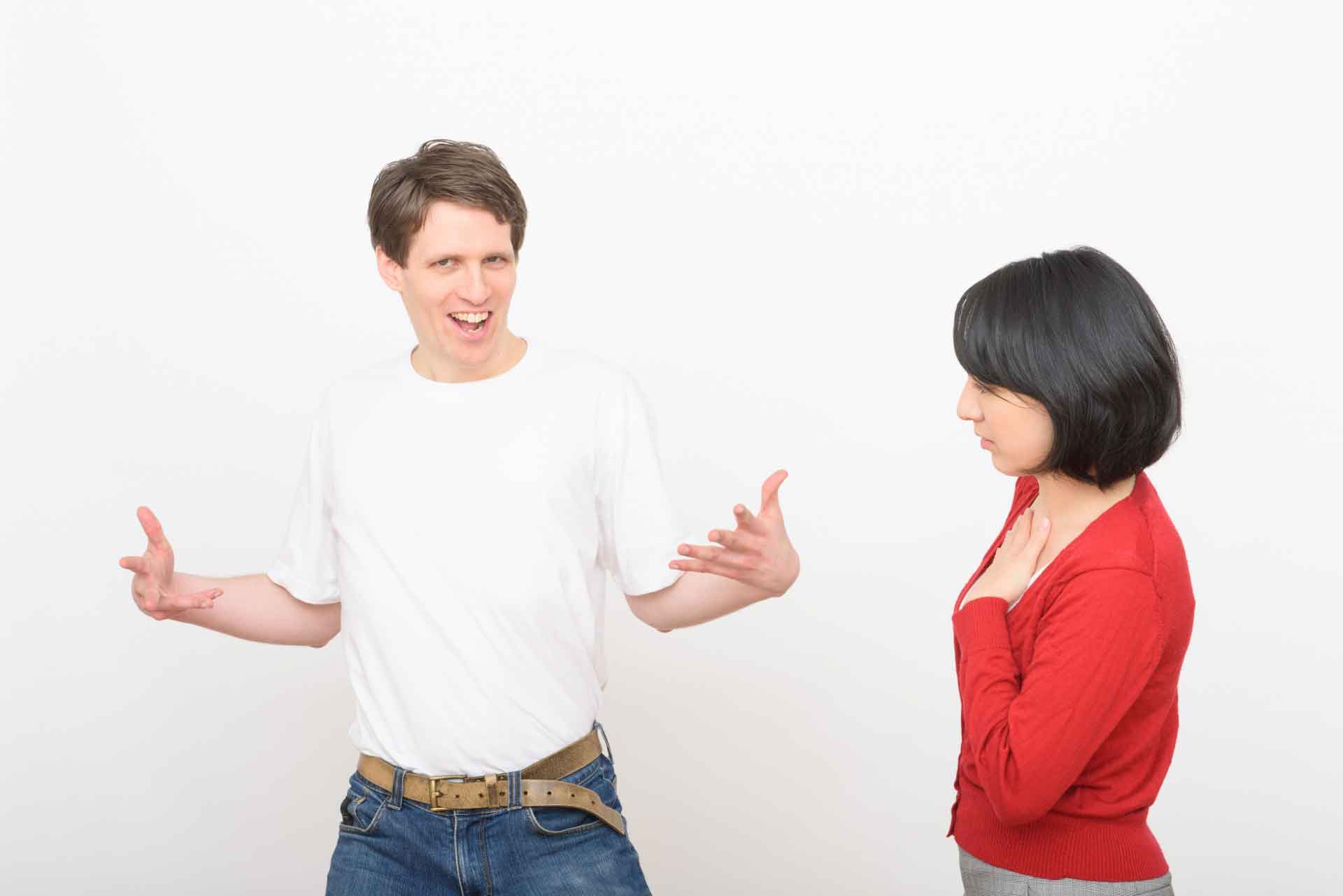 手を広げドヤっている外国人男性を冷ややかに見つめる女性