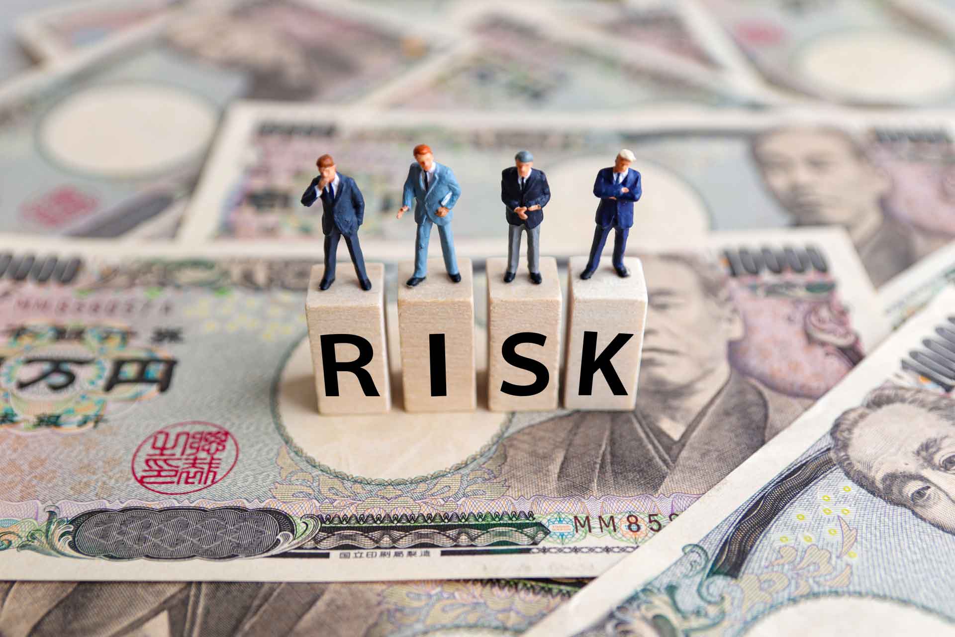 RISKの文字の上に立つ男性のミニチュア