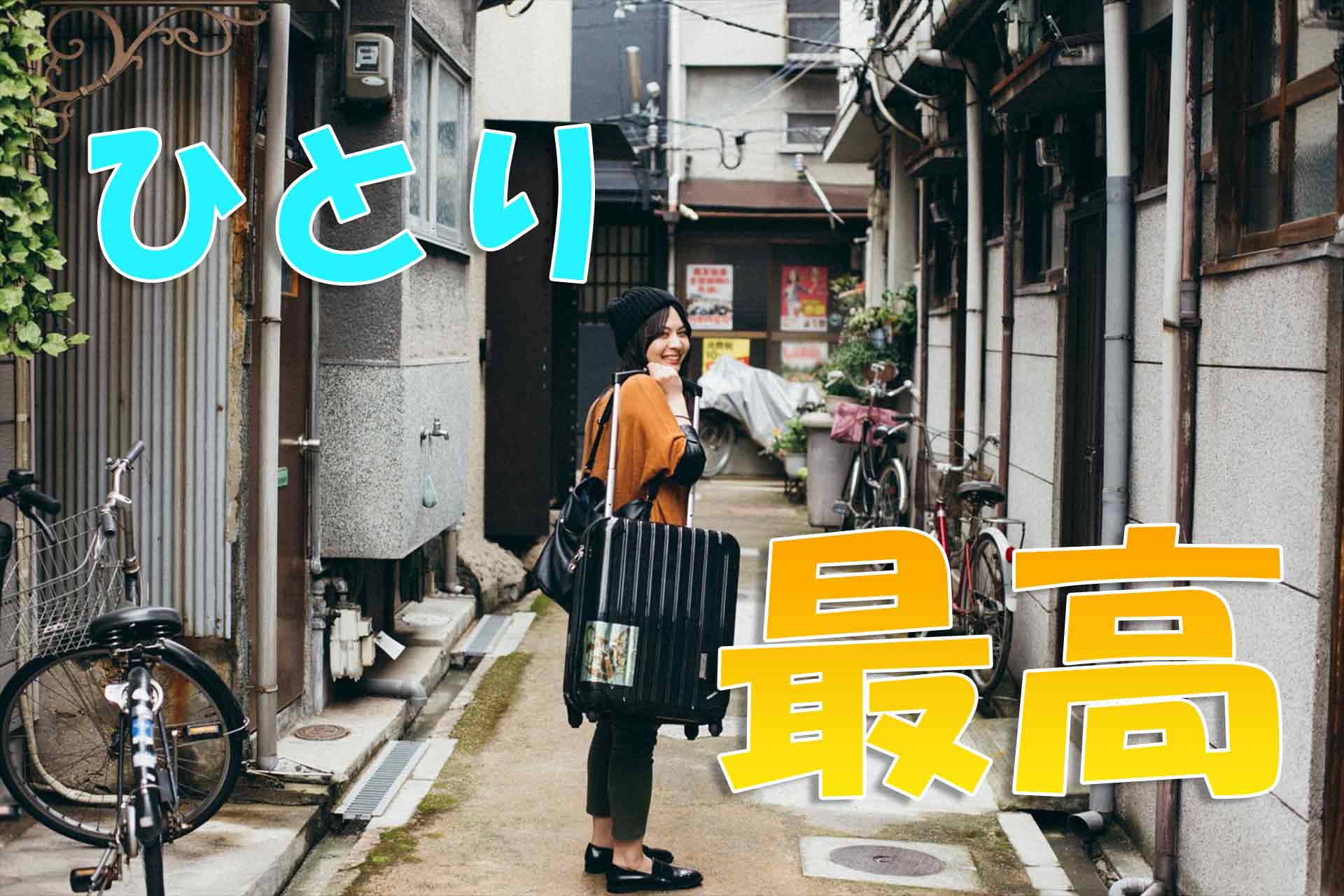 スーツケースを持ち笑顔で振り返る女性と「ひとり 最高」の文字