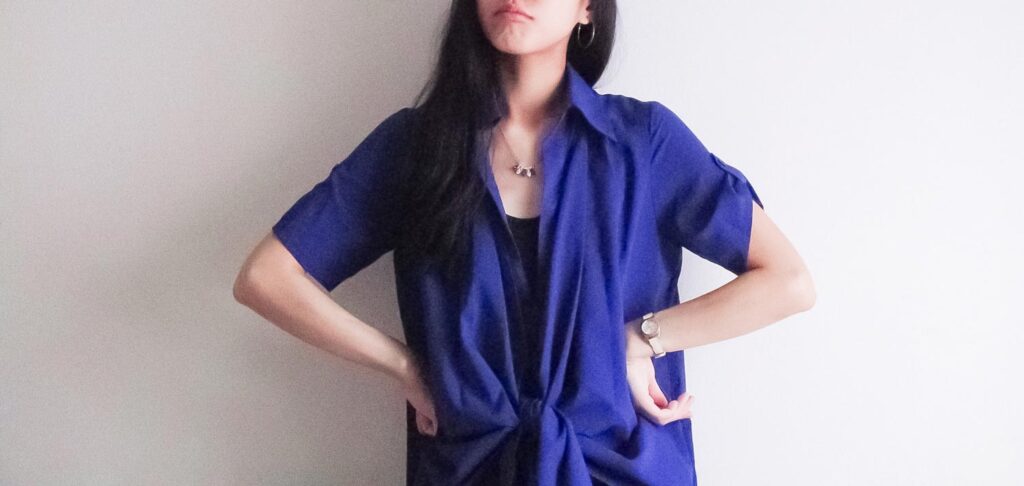 腹を立てた風に腰に手をあてている女性