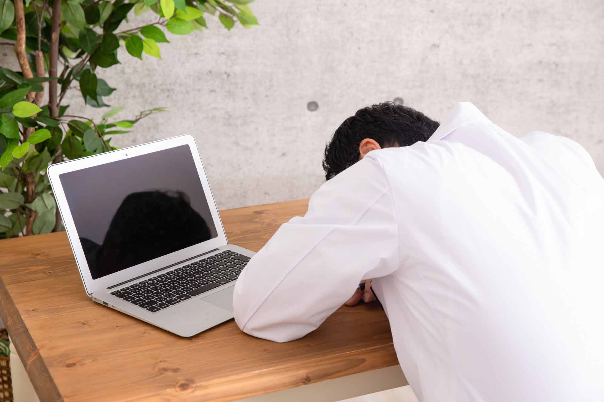 テーブルに突っ伏して寝ているサラリーマン
