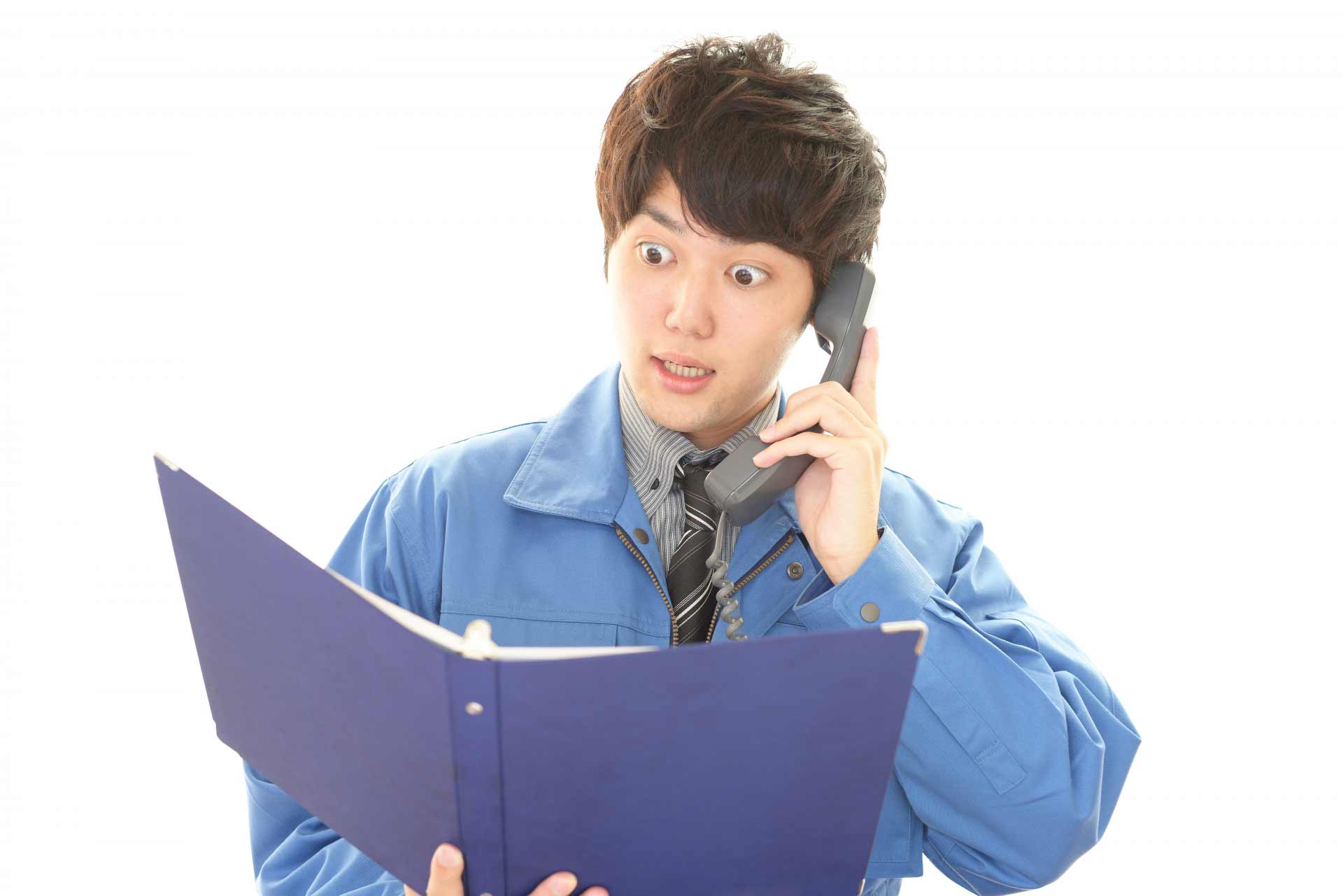 目を大きく見開いて電話をかけている男性