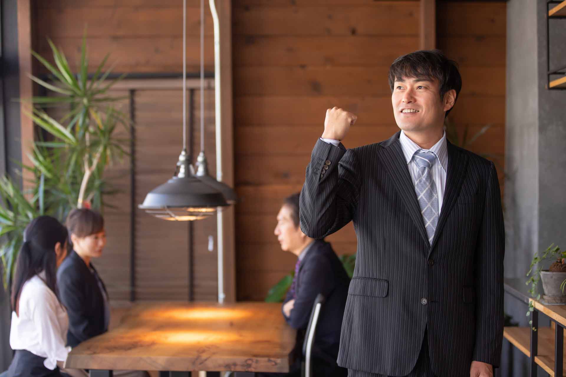 オシャレなオフィスでガッツポーズをしているサラリーマン
