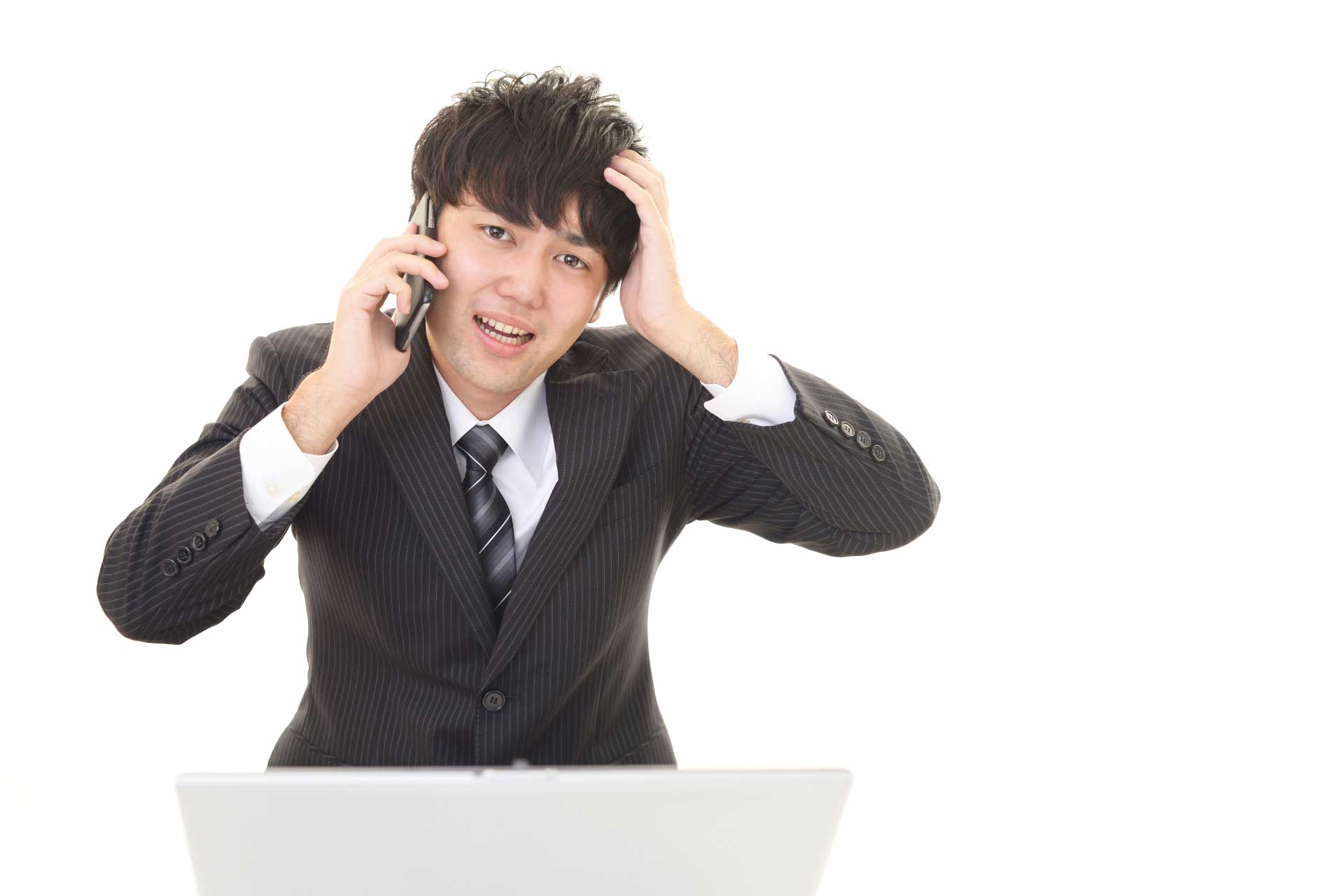 電話をしながら頭を抱えている男性