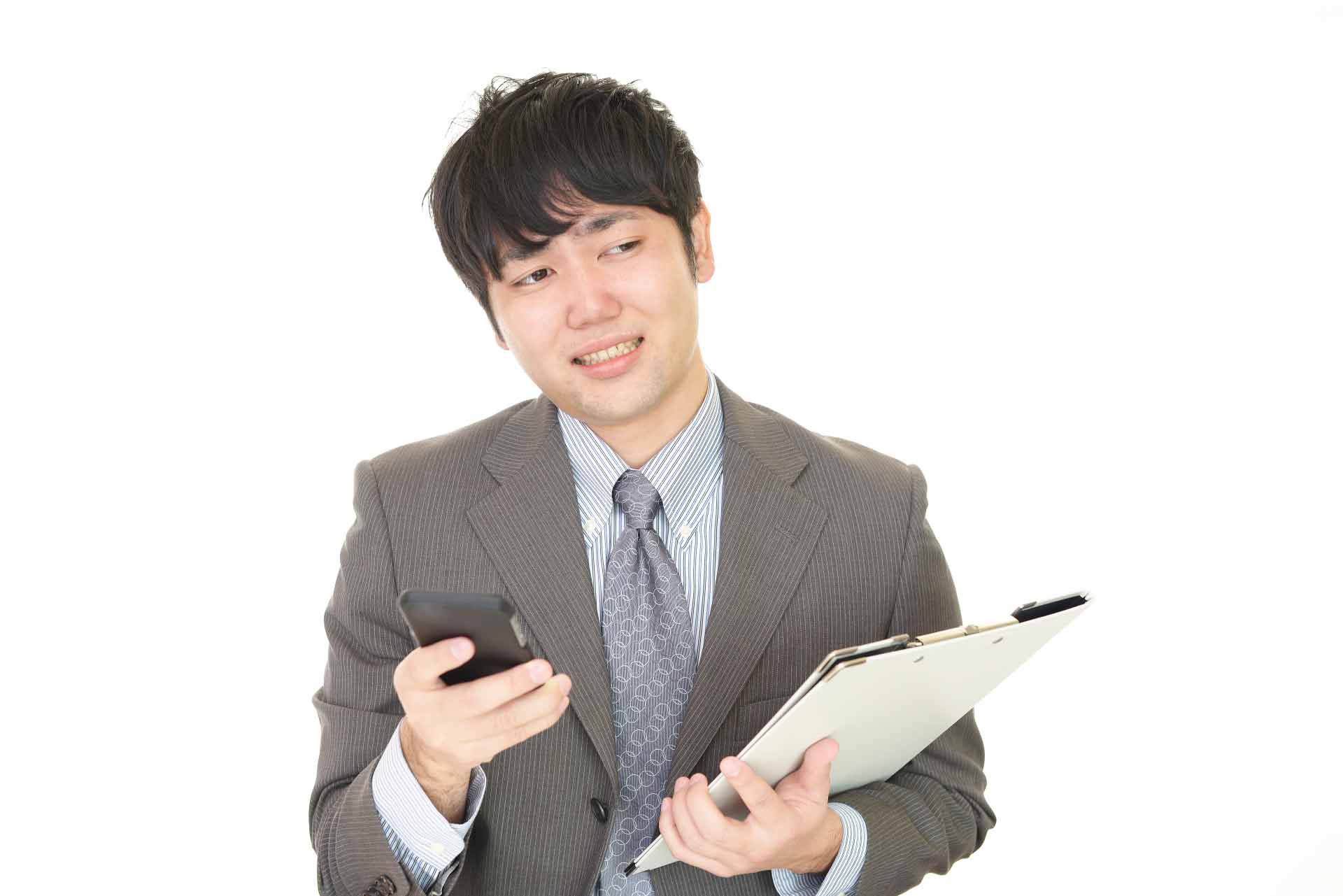 携帯とバインダーを持ち困っている様子のサラリーマン