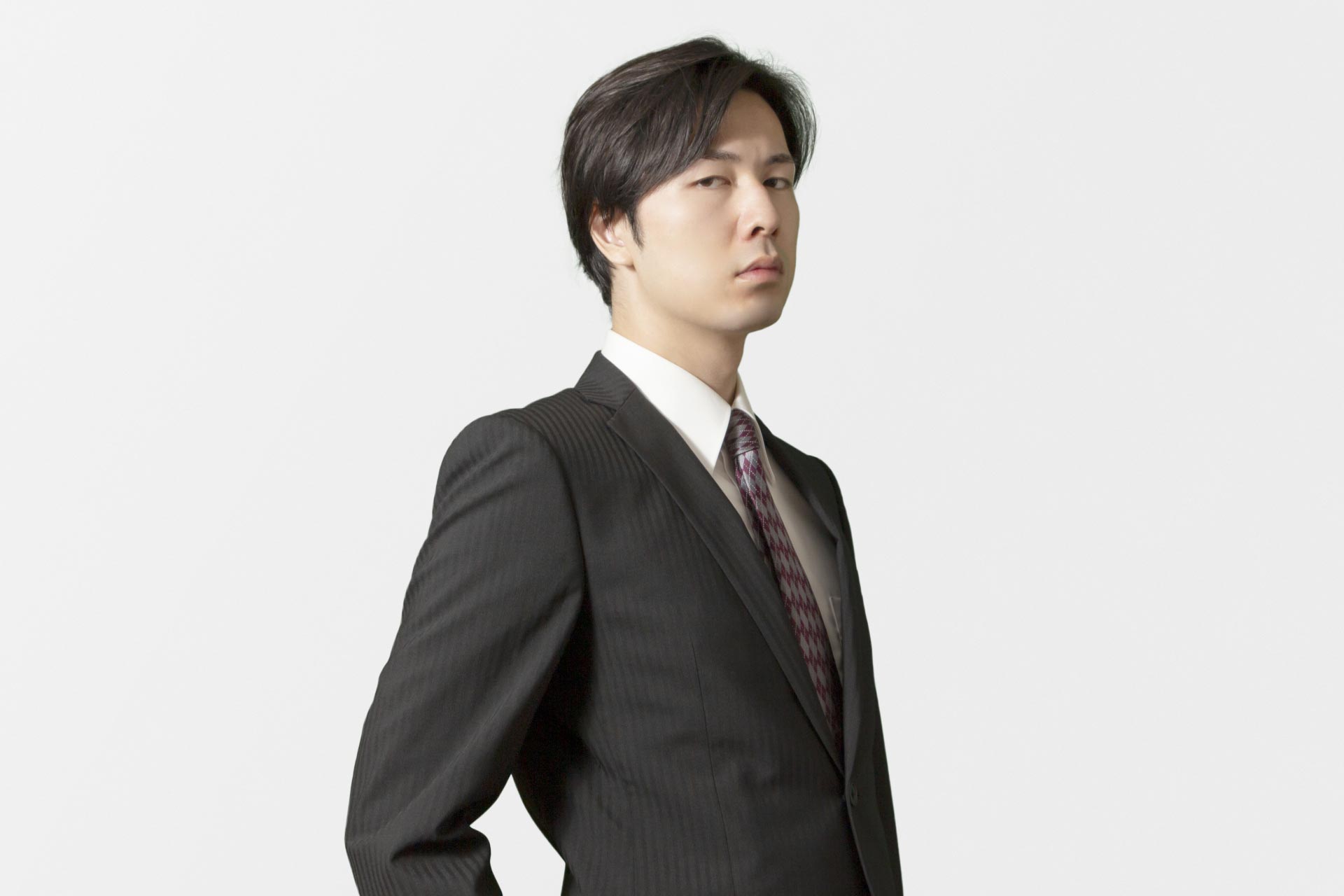 さげすむような視線を送るスーツ姿の男性