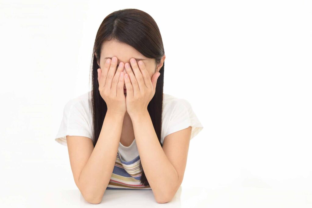 顔を押さえて泣いている様子の女性
