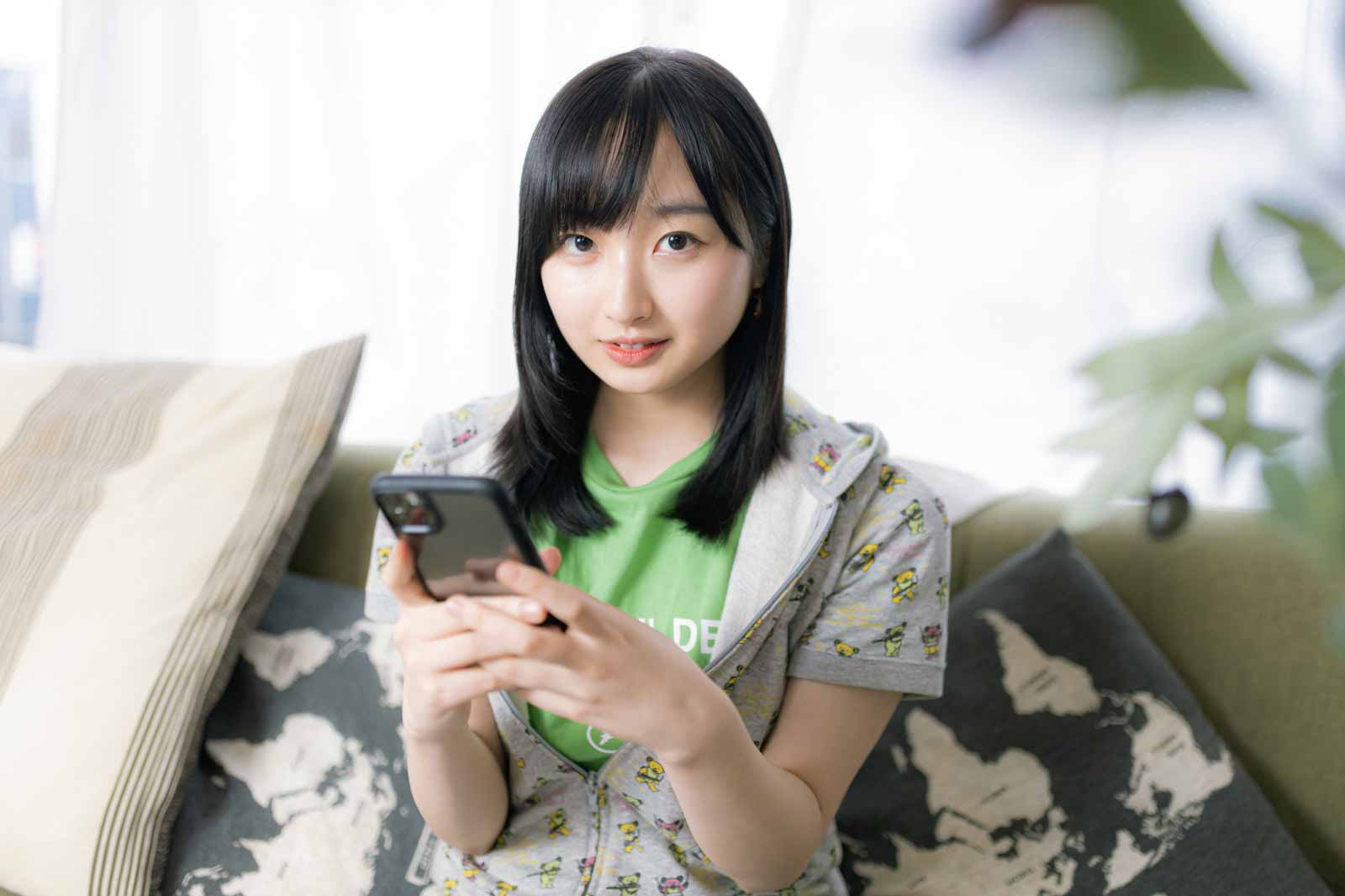 スマホを持って上目遣いでこちらを見ている女性