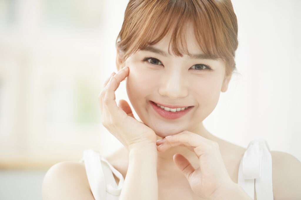 頬に指をあててほほ笑む女性