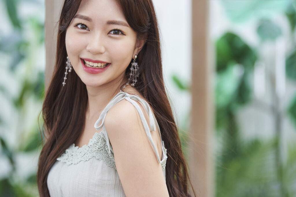 笑顔でこちらを振り返るノースリーブの女性