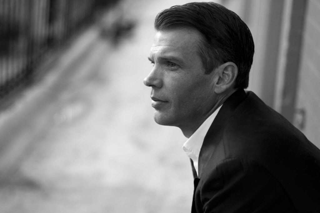 遠くを見つめるスーツ姿の外国人男性の横顔